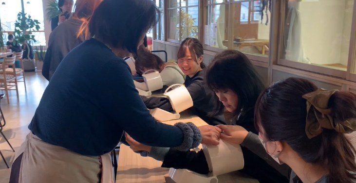 設置された血圧計で血圧を測る社員