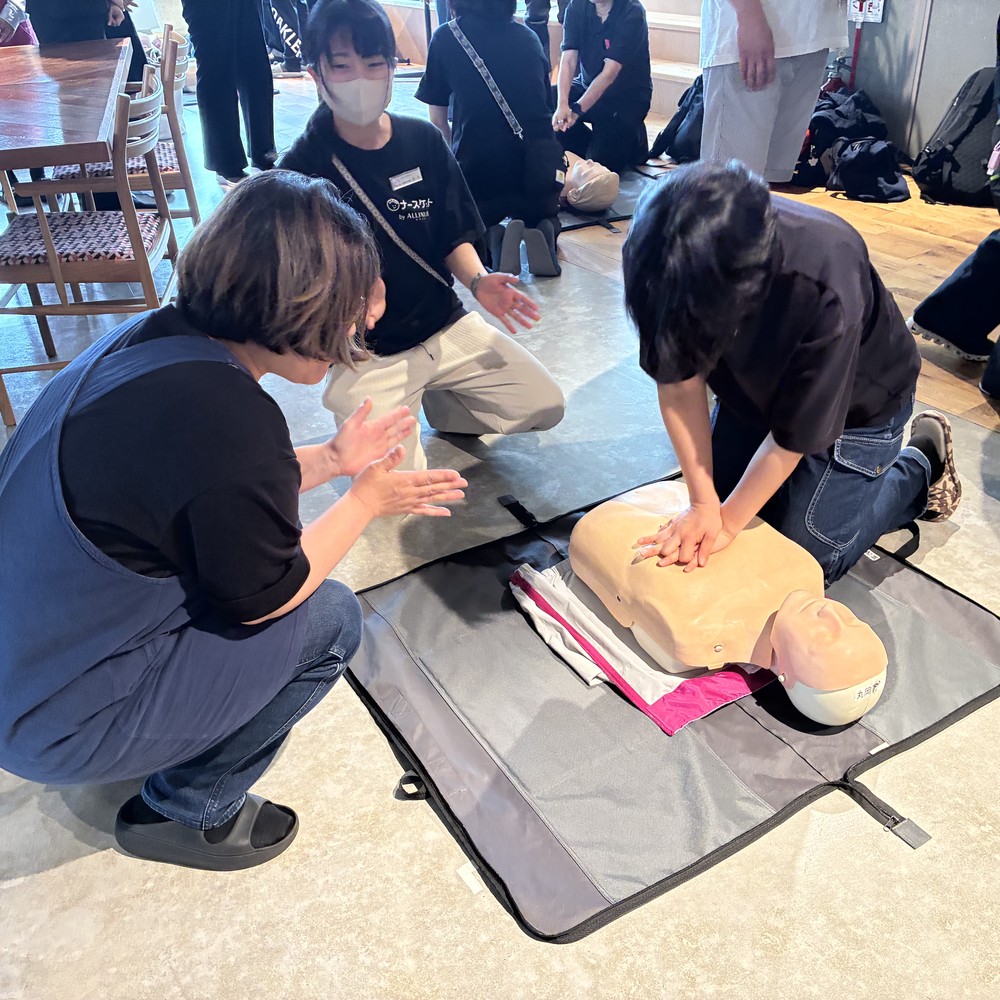 訓練用の人形を使って胸骨圧迫を練習する社員